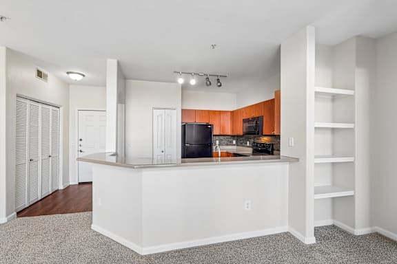 A kitchen with a white counter and a TV on the wall.