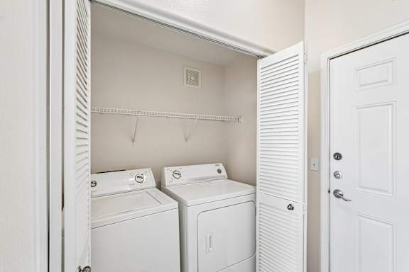 A white laundry room with a washer and dryer.