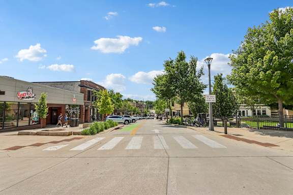 A street view with a crosswalk and a sign on the right.