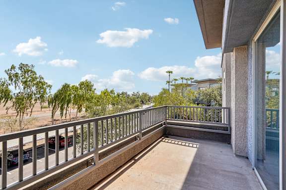 A balcony with a metal railing and a concrete pillar.
