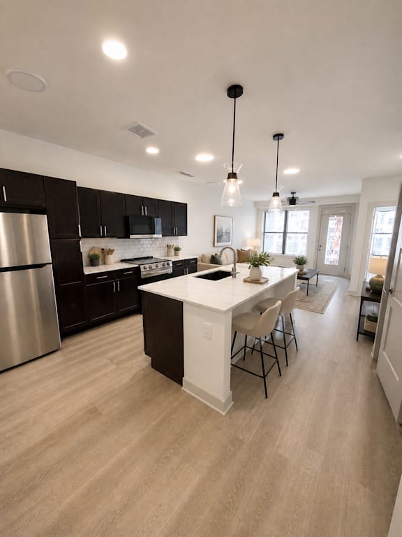 A modern kitchen with a center island and pendant lights.
