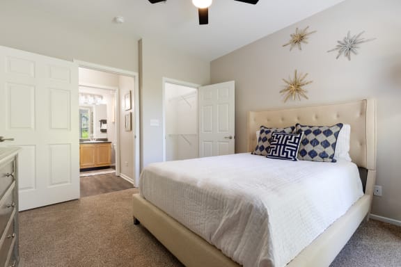 a bedroom with a large white bed and a closet