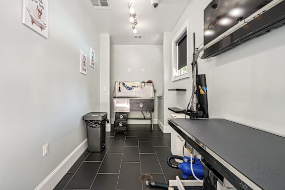 A clean, empty kitchen with white walls and black tile flooring.