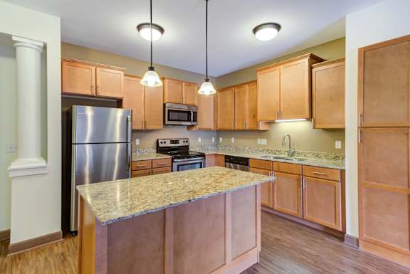 A kitchen with wooden cabinets and a granite countertop.