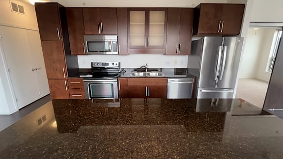 A kitchen with brown cabinets and a dark brown counter top.