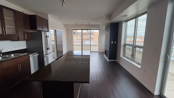 A kitchen with dark wood floors and stainless steel appliances.
