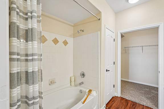 A bathroom with a white tub and a shower curtain.