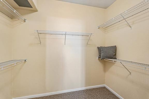Empty room with three shelves and a pillow on one of them.