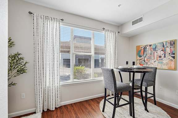 A dining room with a table and chairs.