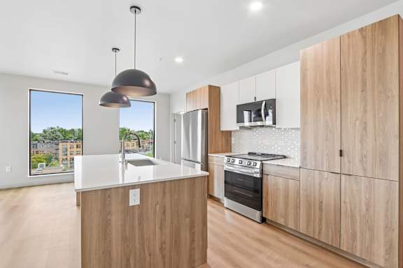A modern kitchen with wooden cabinets and a large island.