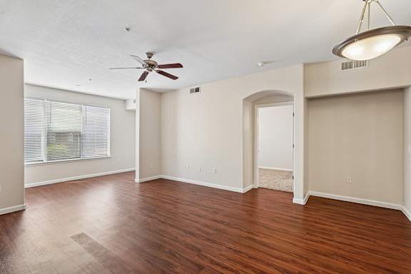 A room with a ceiling fan and a light fixture.