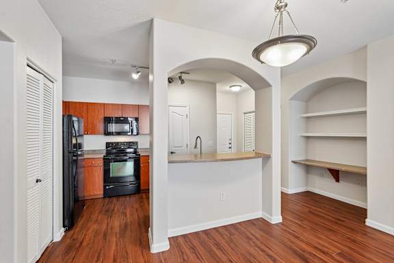 A kitchen with a refrigerator, microwave, and oven.