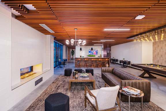 A modern living room with a fireplace and a pool table.