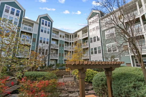 a view of an apartment building with a garden in front of it