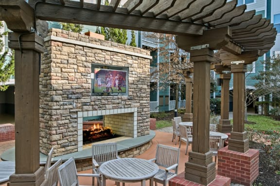 a patio with a fireplace and tables and chairs