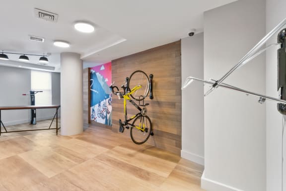 a bike is hanging on a wall in a room with wood floors and a wall
