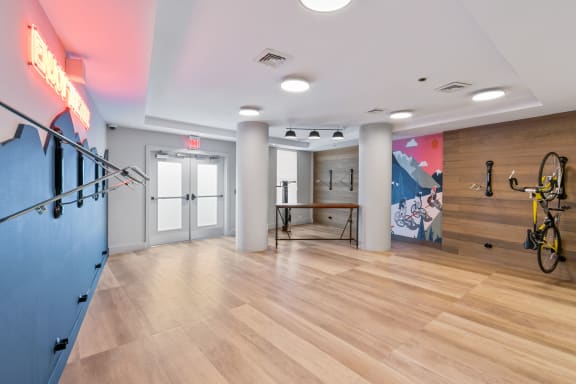 a workout room with a bike rack and a wall with a mural