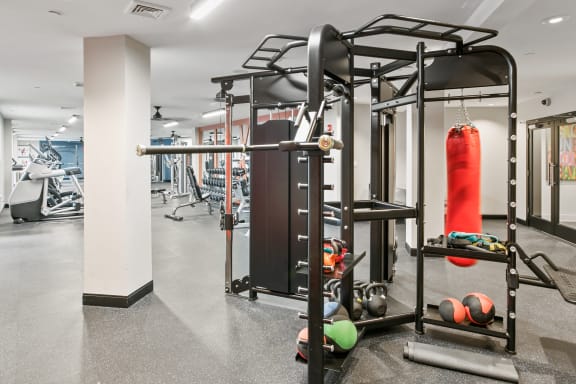 a gym with weights and a punching bag in the center of the room