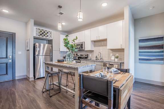 A modern kitchen with a wooden island and bar stools.