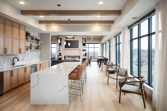 a large kitchen with a large island and a long table with chairs