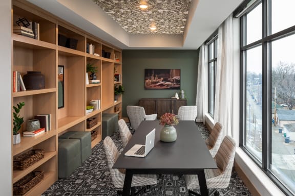 a conference room with a large window and a table with a laptop