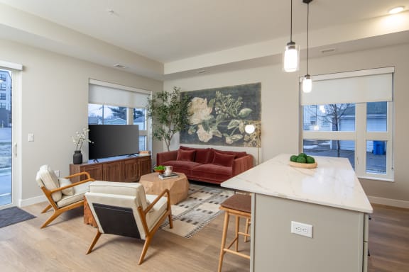 a living room with a couch and a table with chairs and a kitchen