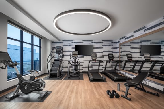a gym with treadmills and other exercise equipment and a large window