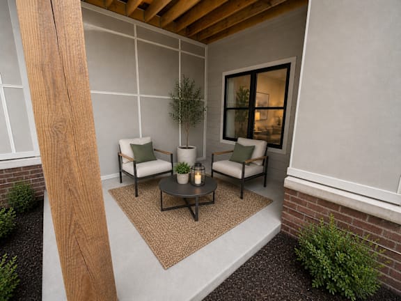 A cozy outdoor seating area with a couch, chairs, and a table.