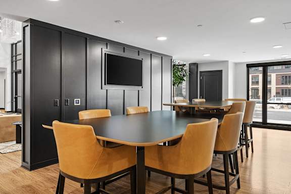 A black and tan conference room with a large table and chairs.