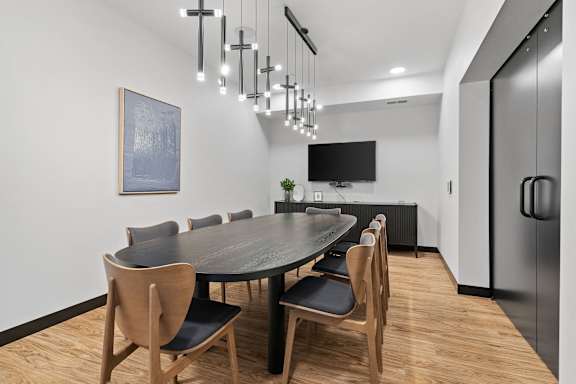 A modern dining room with a large table and chairs.
