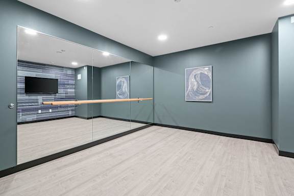 A room with a grey wall and a wooden floor.