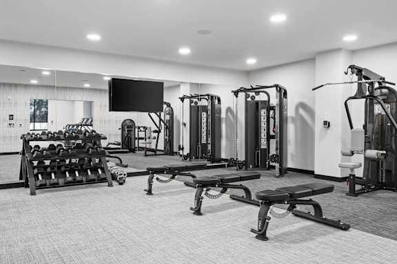 A black and white photo of a gym with a variety of equipment.