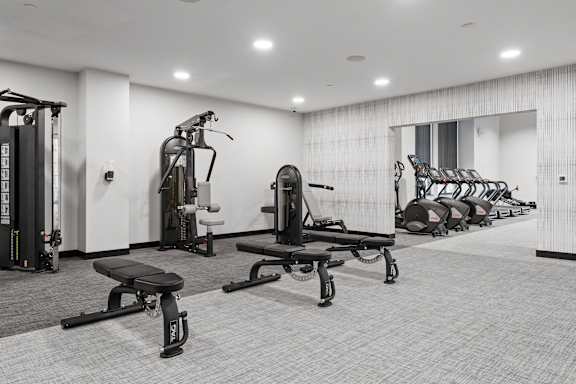 A black and white photo of a gym with a variety of equipment.