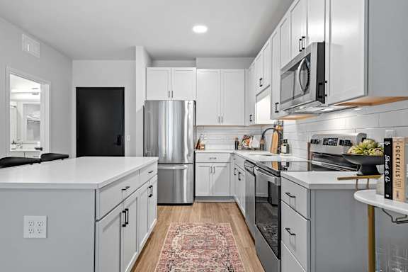 A modern kitchen with stainless steel appliances and white cabinets.