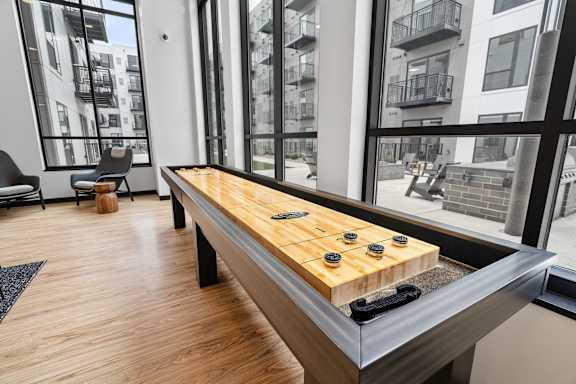 A shiny wooden table with black and yellow game pieces on it.