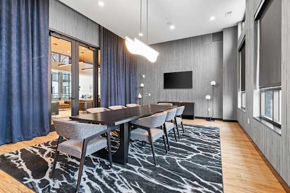 A modern dining room with a long table and chairs.