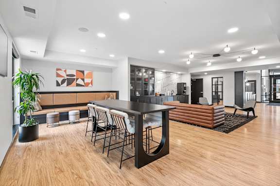A modern living room with a wooden floor and a large sectional sofa.