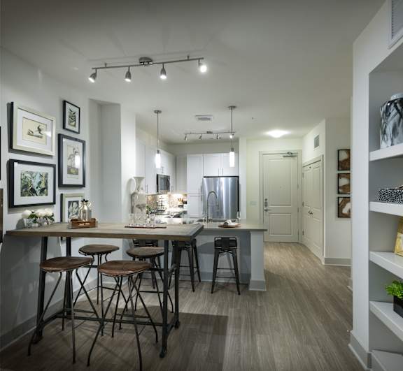 A kitchen with a bar area and a dining table.