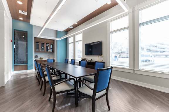 A long table with chairs is set up in a room with a television.
