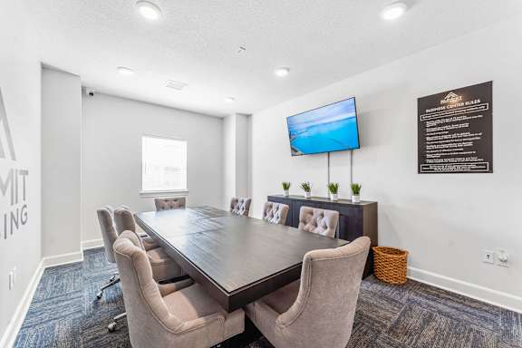 A conference room with a long table and chairs.