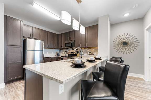 A modern kitchen with a large island and a refrigerator.