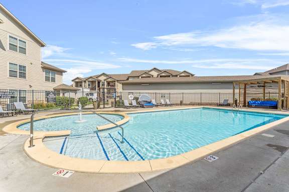 A large outdoor swimming pool with a fountain in the middle.