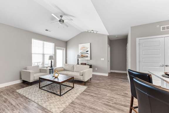 A living room with a ceiling fan and a coffee table.