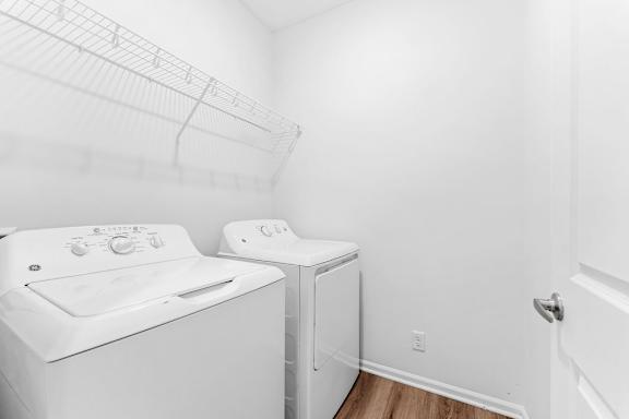 A white washing machine and dryer in a small laundry room.