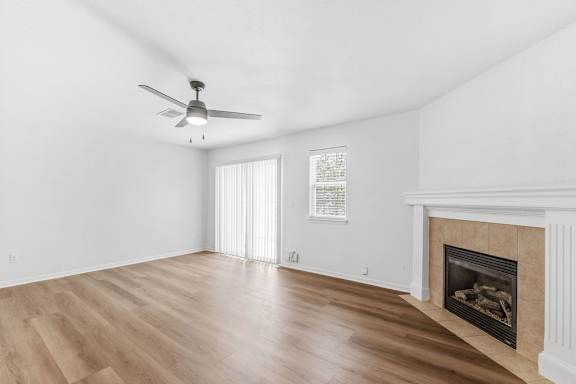 A room with a fireplace and a ceiling fan.