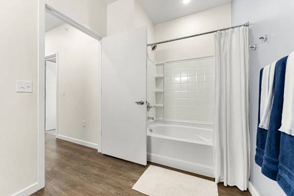 A white bathroom with a white tub and a white door.