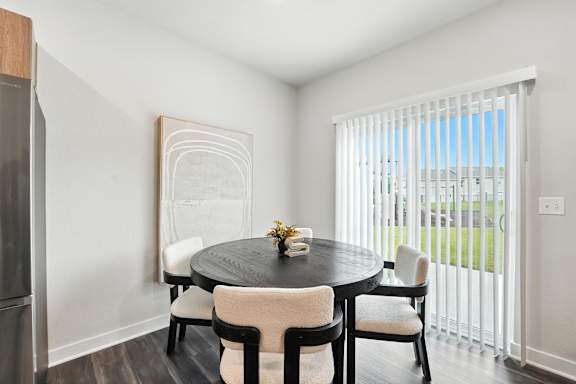 A dining room with a round table and chairs.