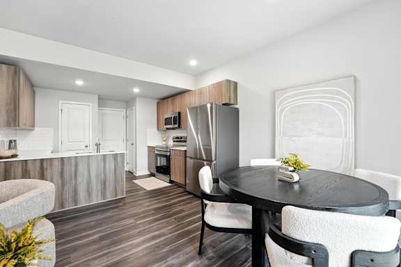 A modern kitchen with a dining table set for two.