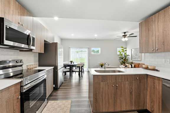 A modern kitchen with wooden cabinets and stainless steel appliances.