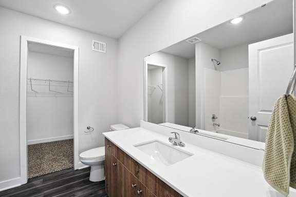 A bathroom with a white sink and a mirror.
